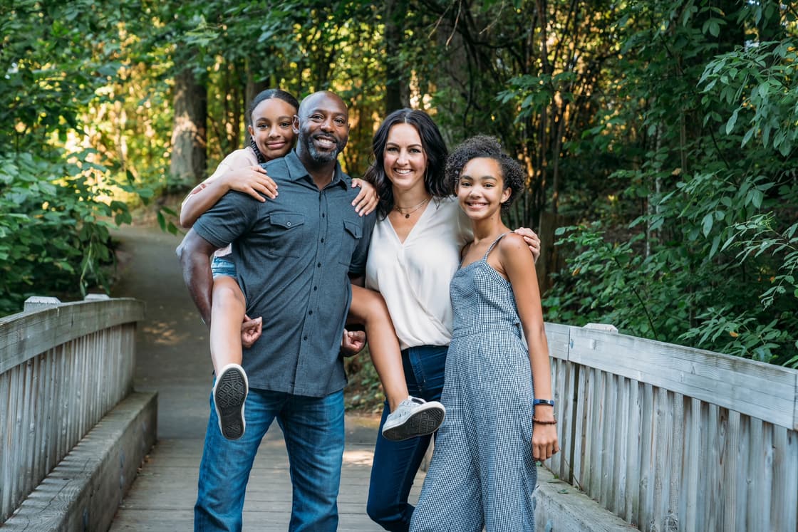 A family with children smiling together outdoors.